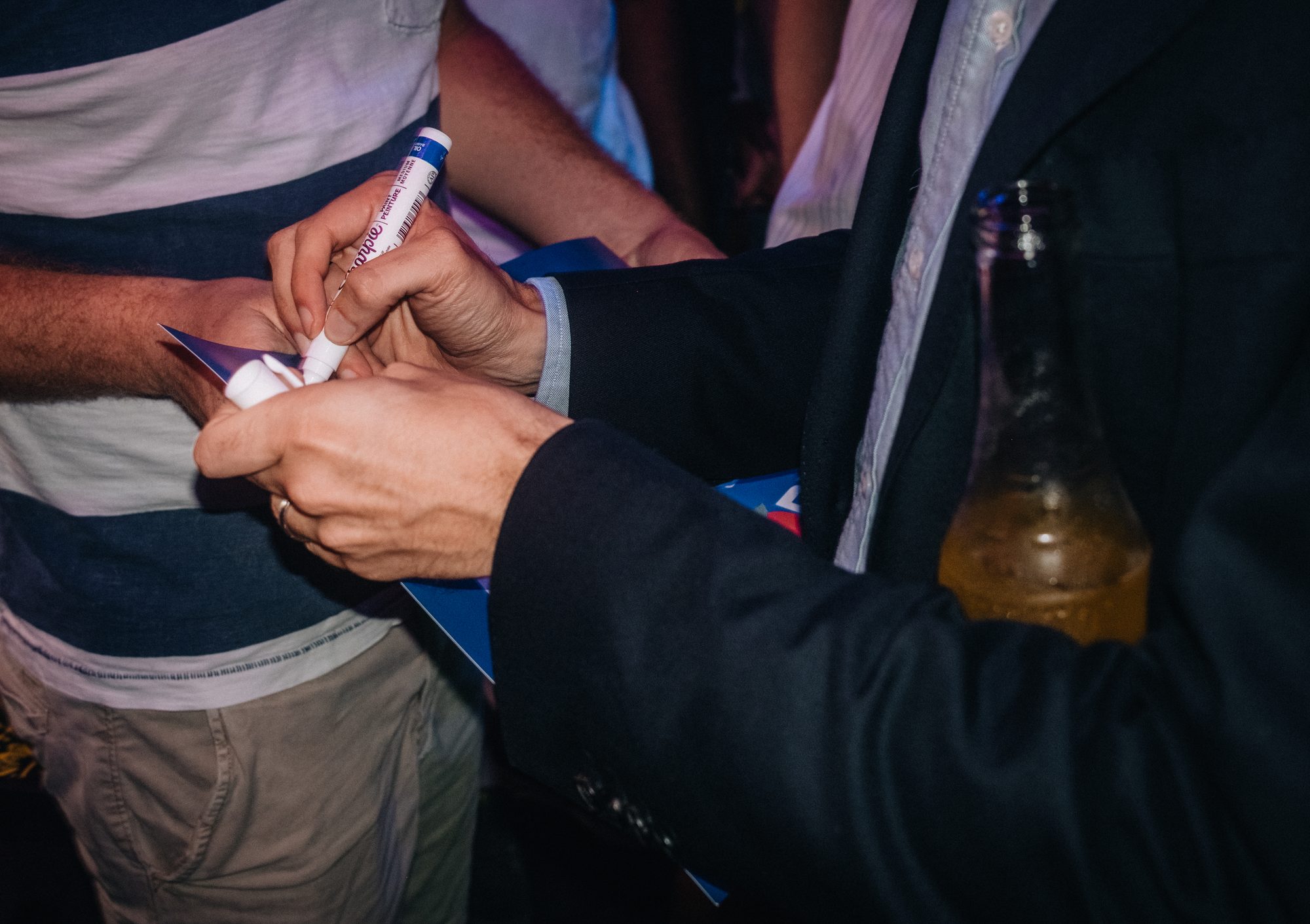 Hands signing a campaign sign, close up