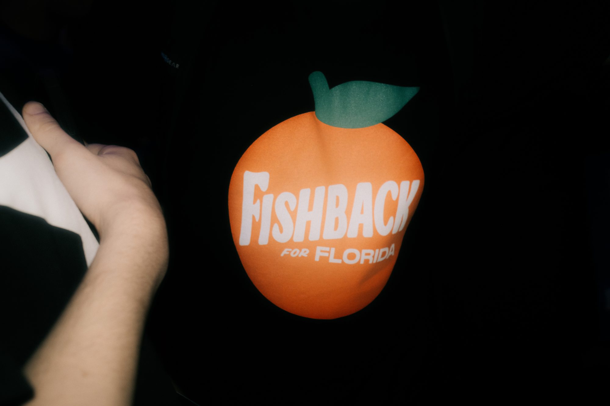 Orange campaign logo held up in the dark