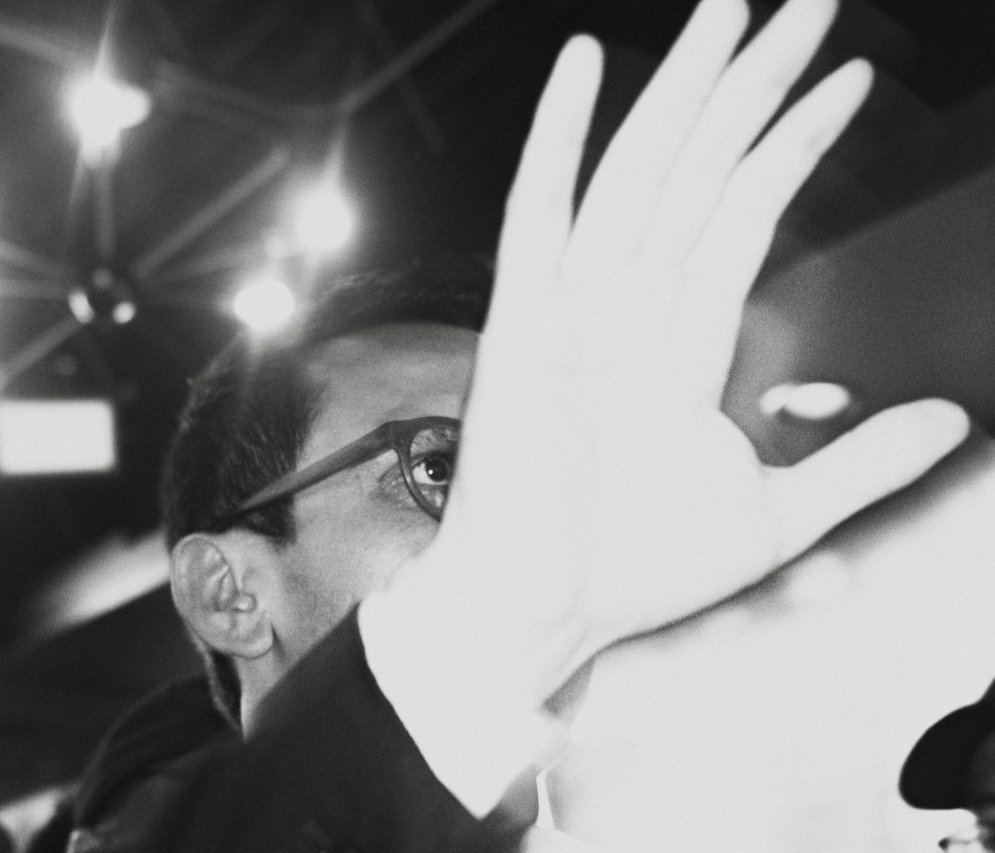 Hand raised in front of the candidate's face, black and white