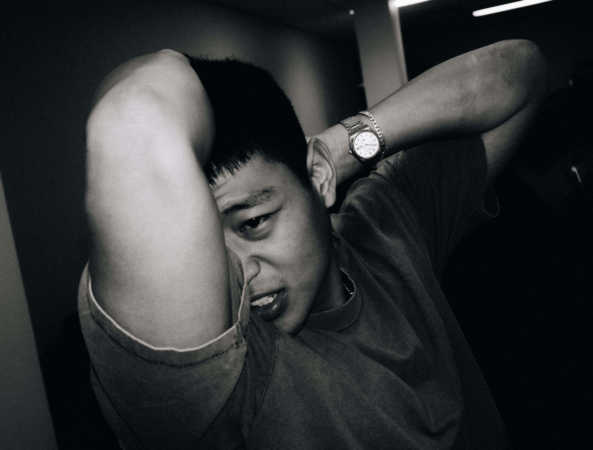 Crew member resting his head on his arm, black and white