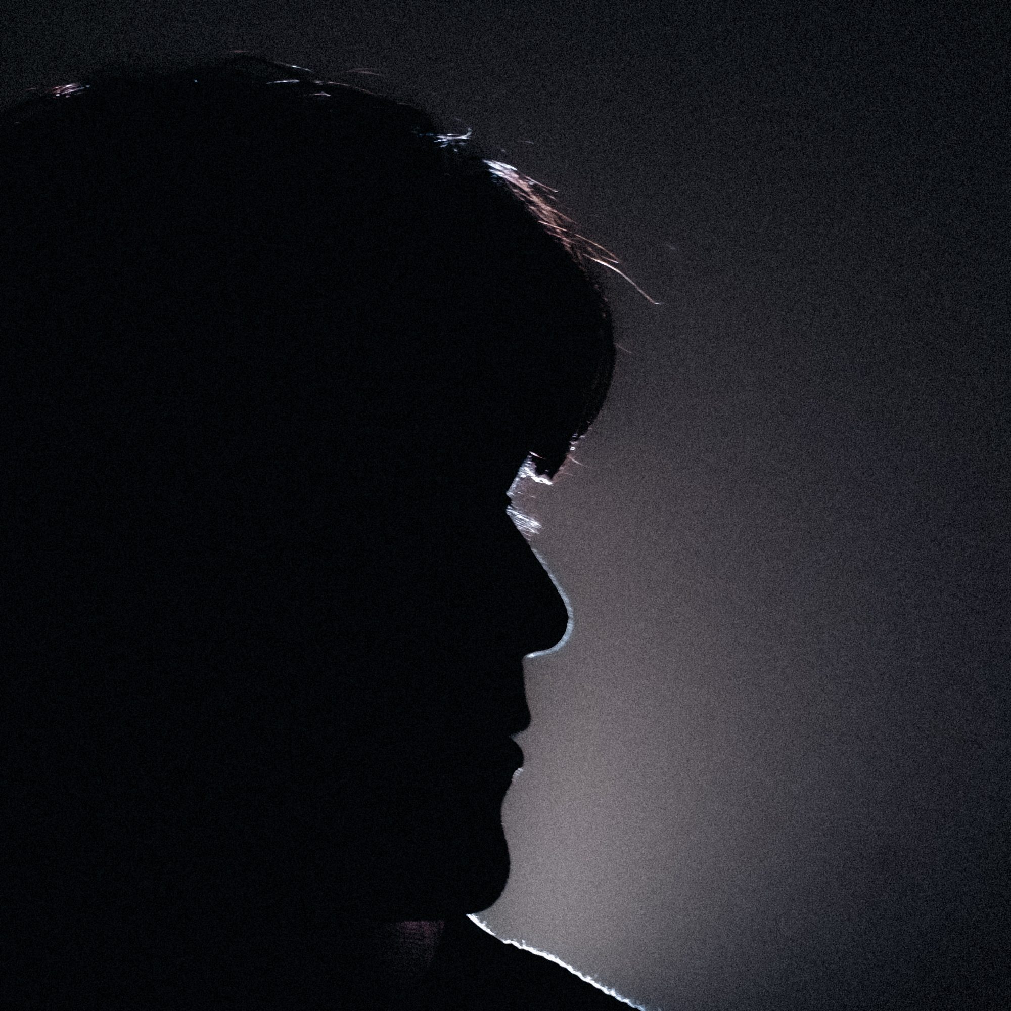 Silhouette of a crew member against a lit wall