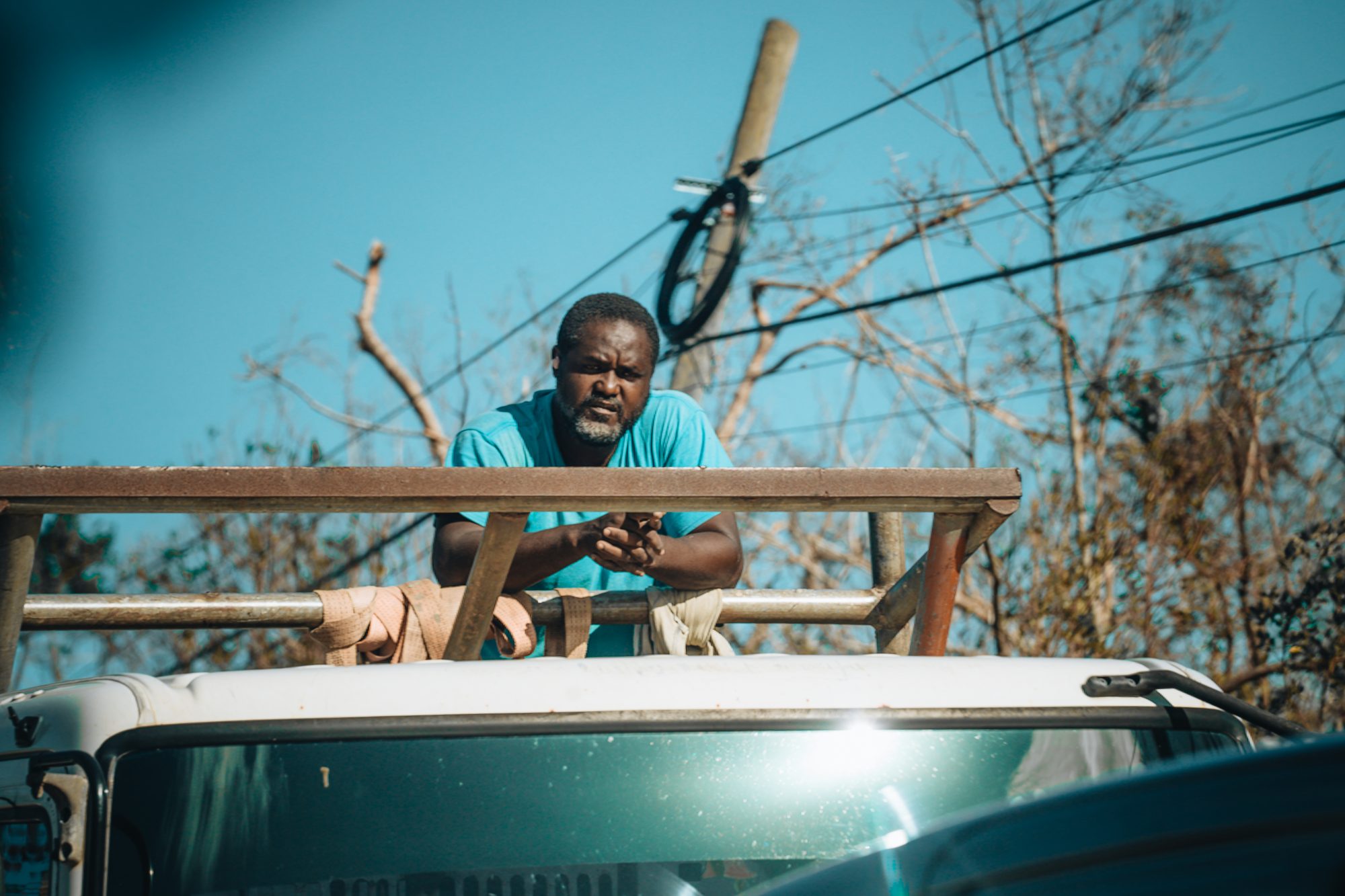 Man on the roof of a truck under downed power lines