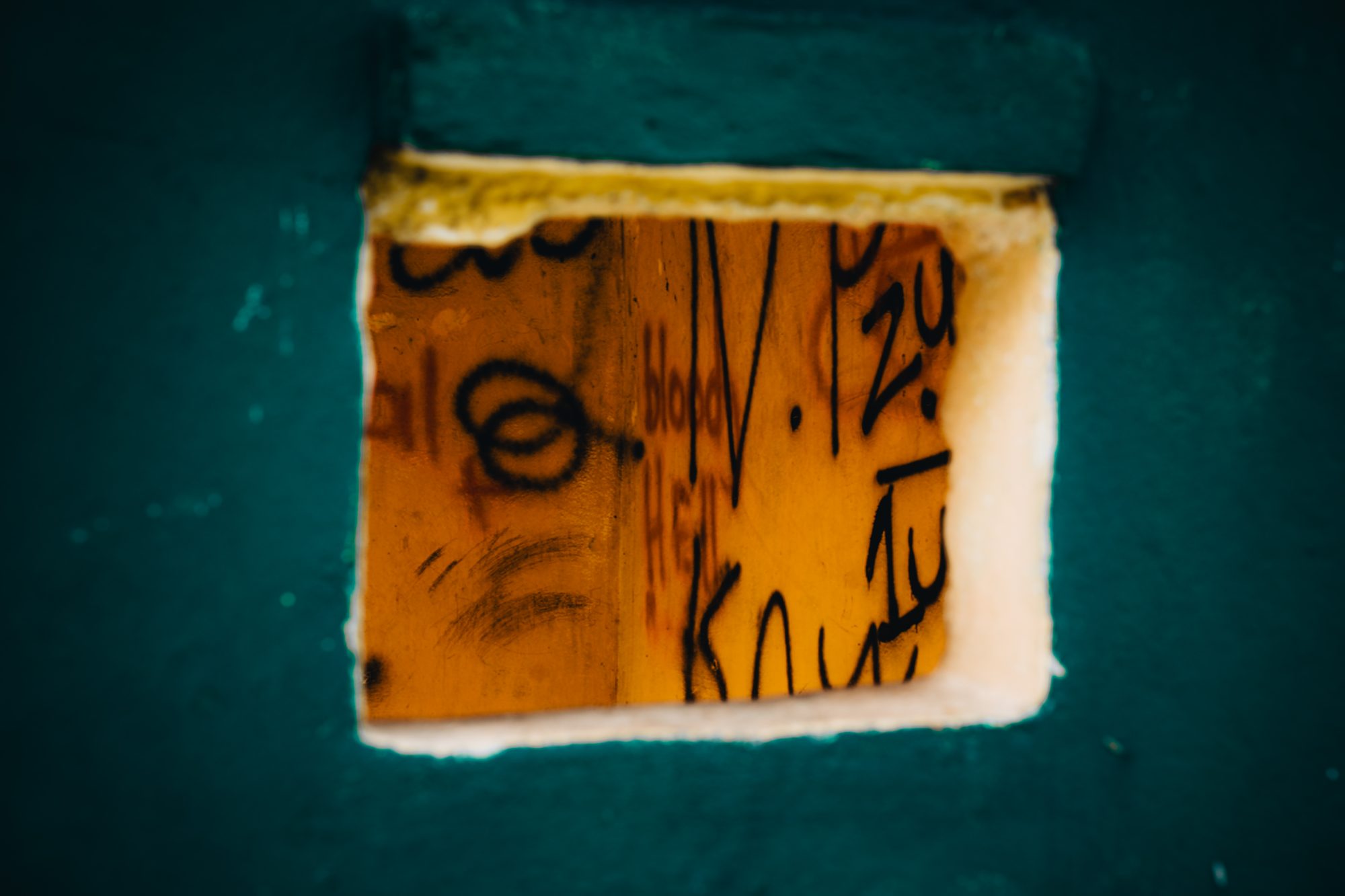 Handwritten notes on a board behind a small window