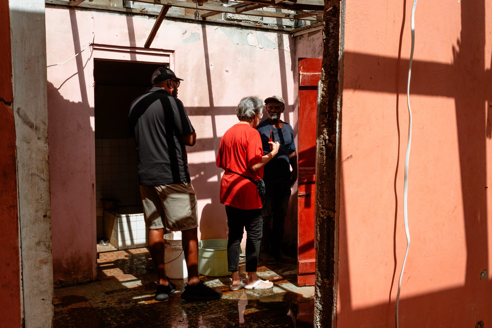 Volunteers carrying supplies through a red doorway
