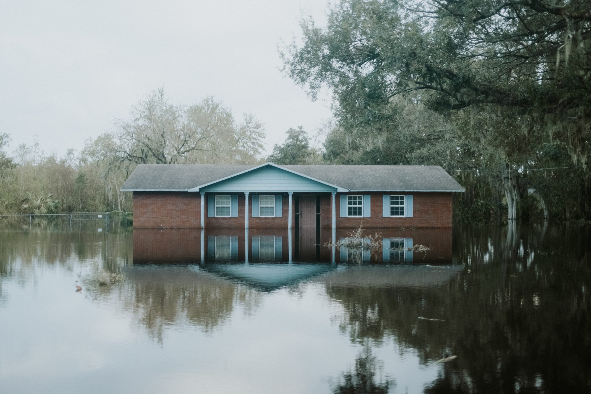 Brick house reflected in floodwater up to its windows