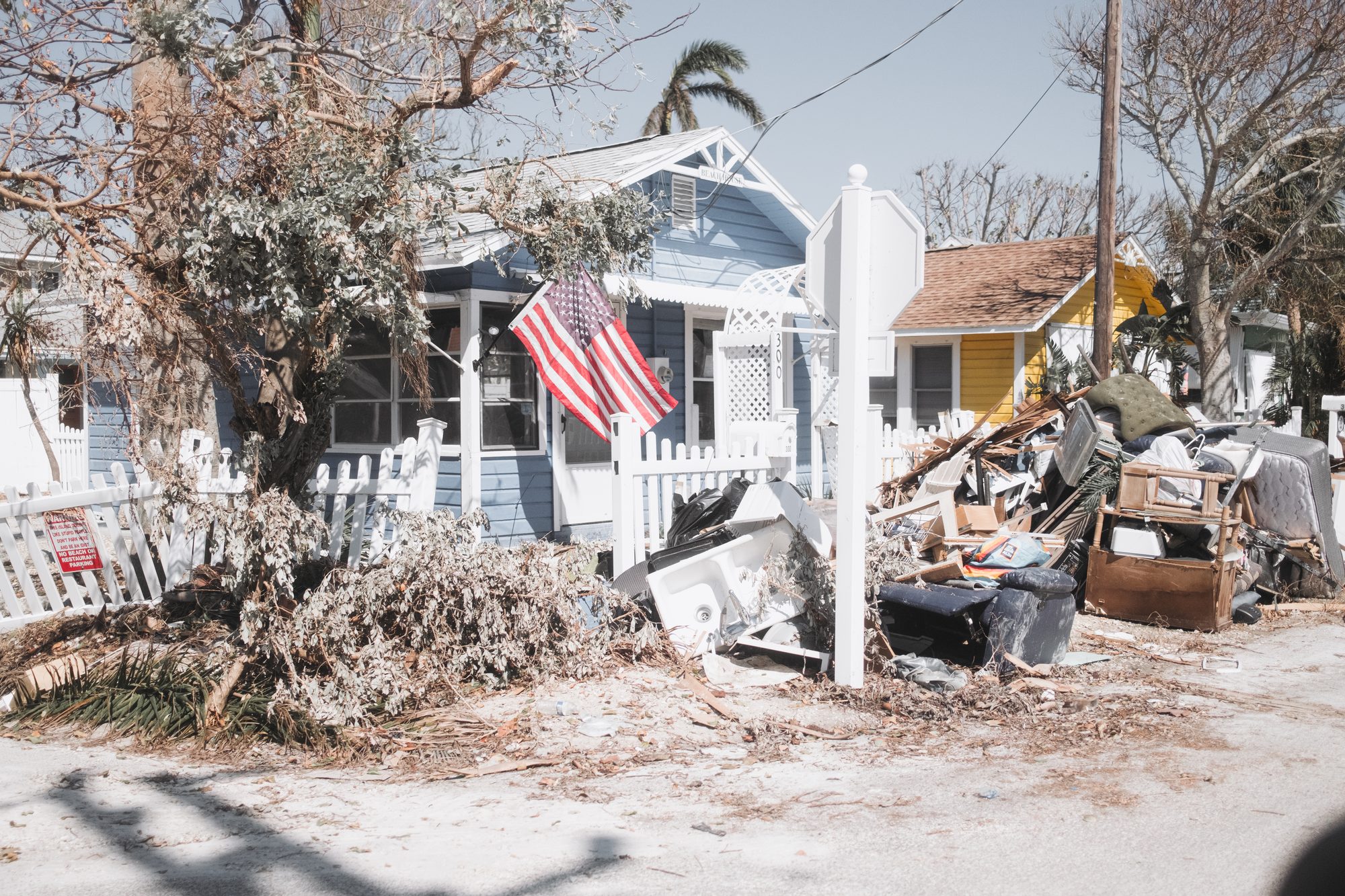 Front yard of debris with an American flag
