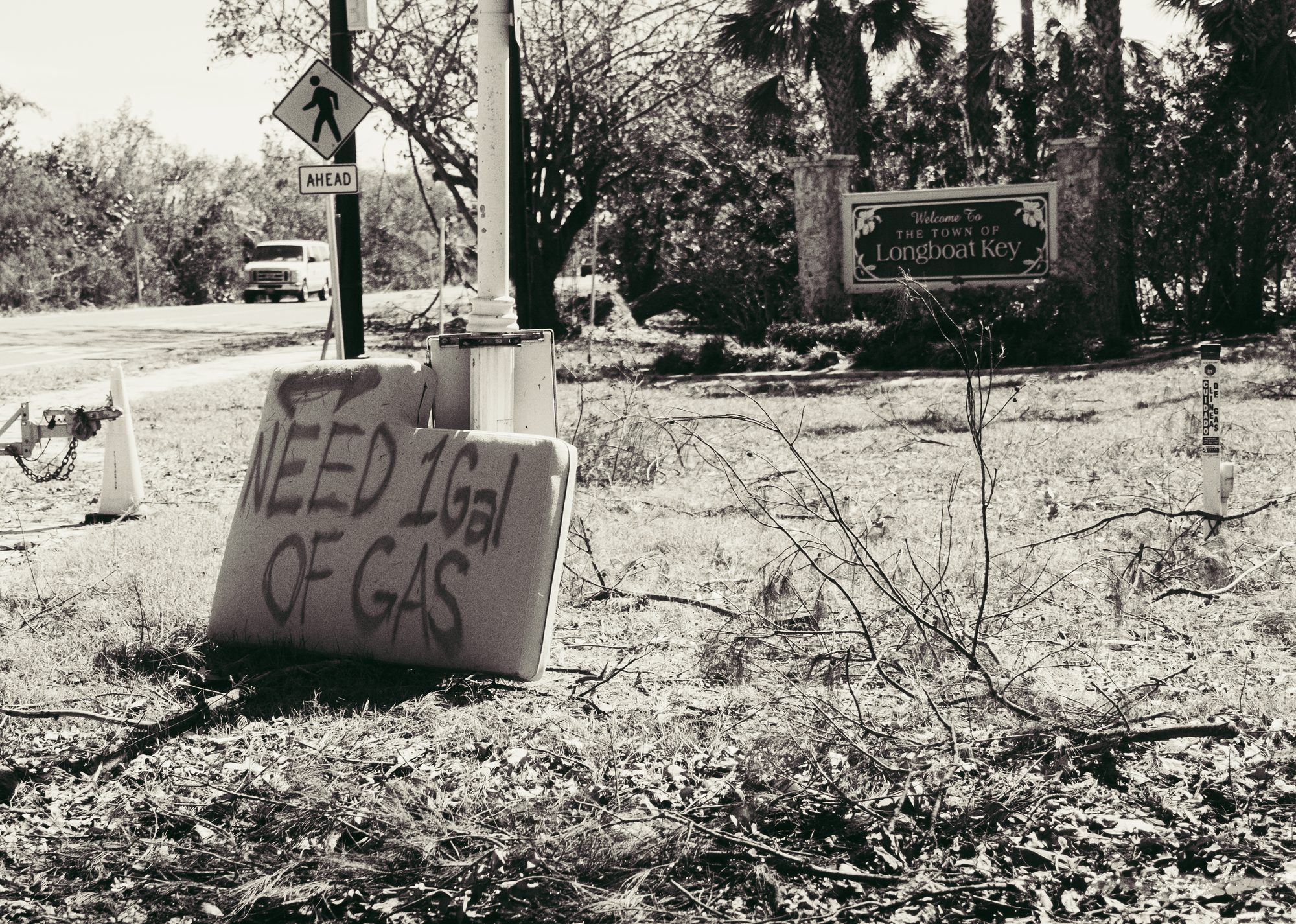 Handwritten sign asking for one gallon of gas, black and white