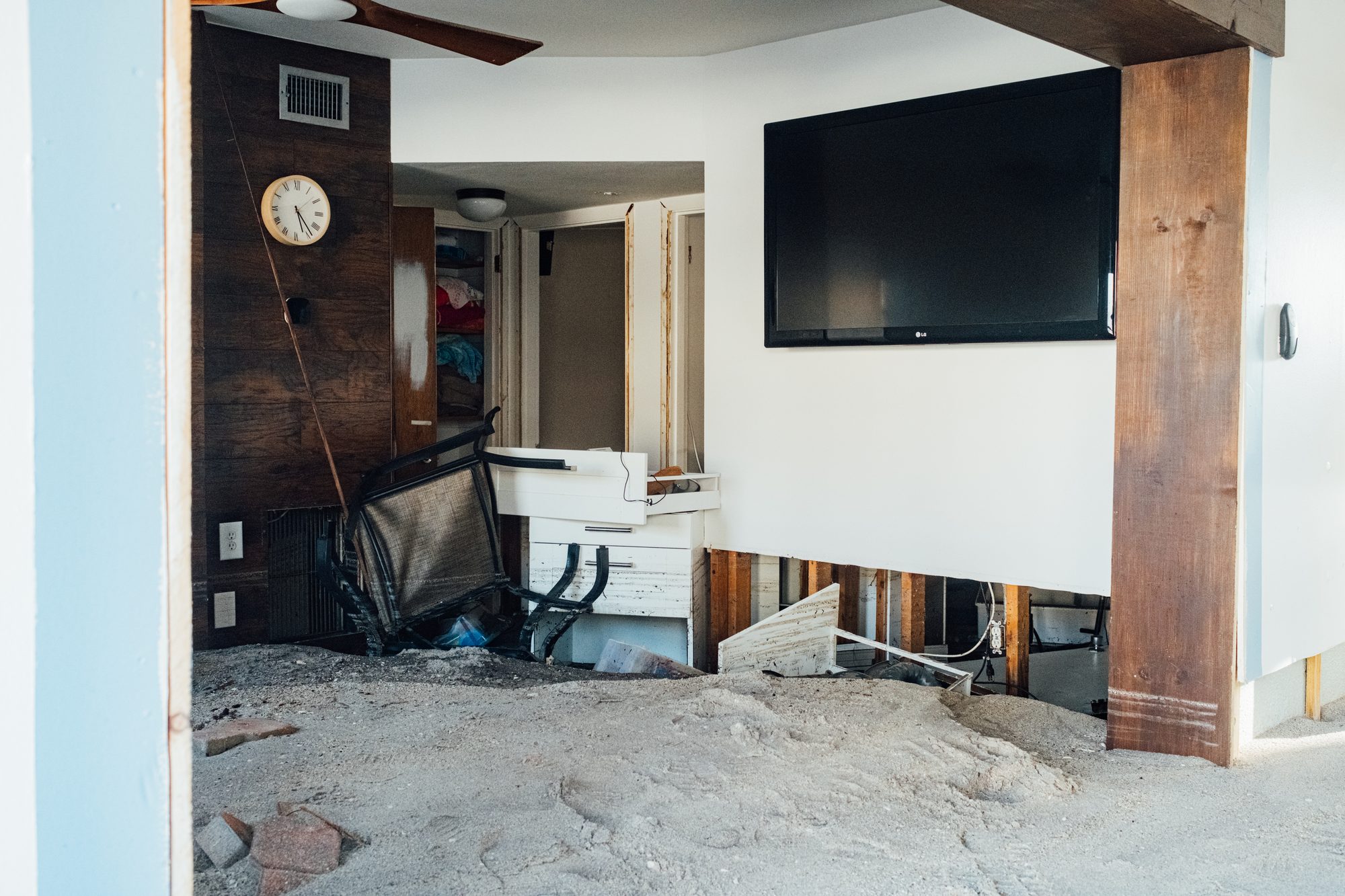 Gutted living room with sand across the floor